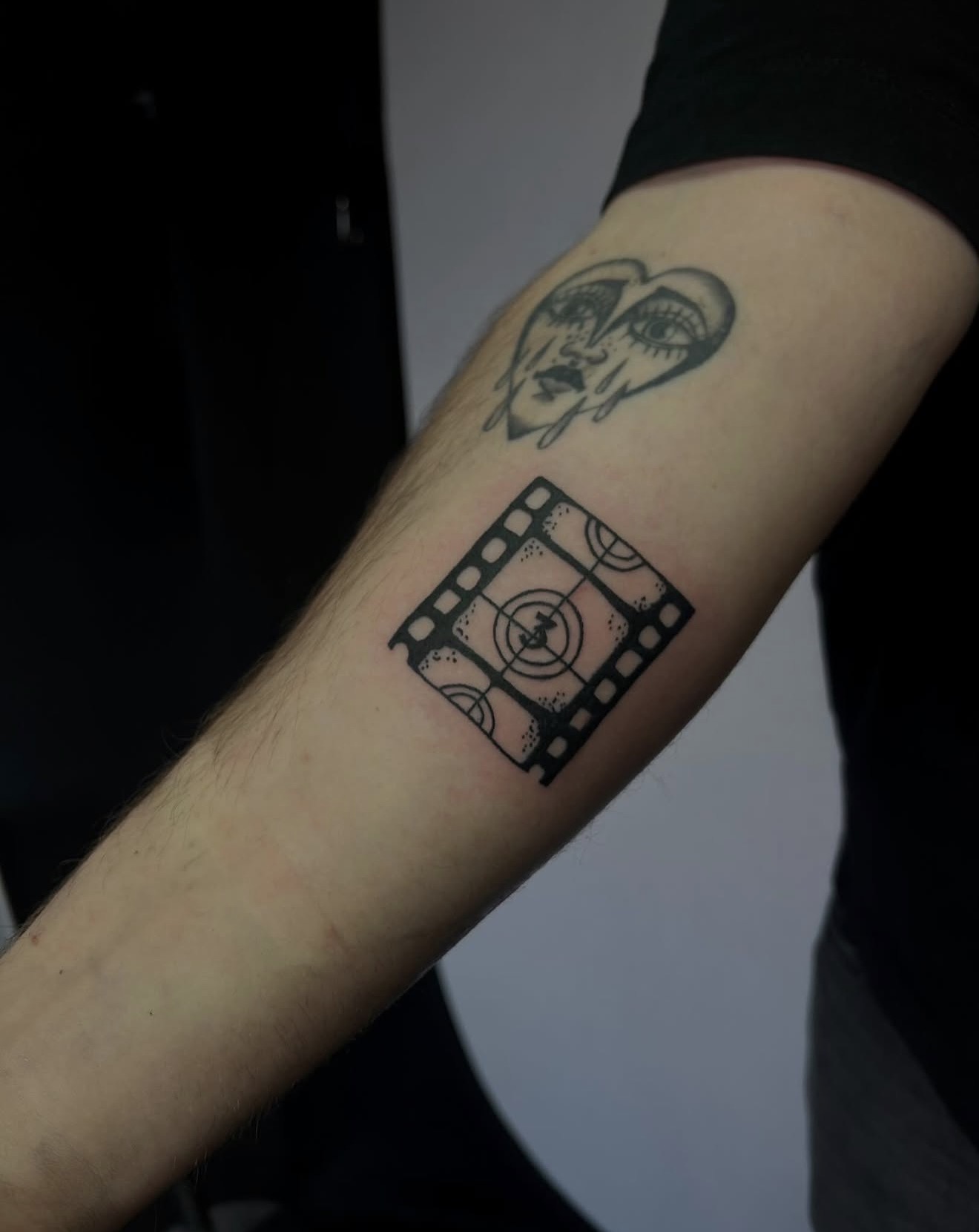 Film strip and heart, forearm